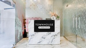 Una mesa de recepción con un letrero que dice 'TOWNHOUSE Company Serviced'.