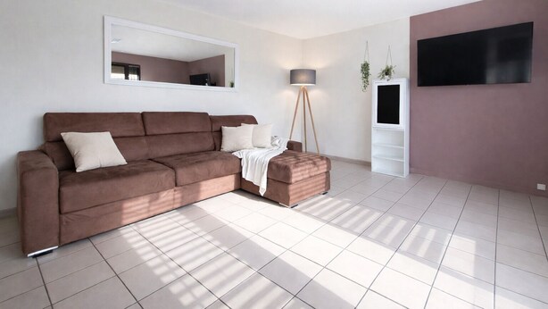 A modern living room with a brown sofa, a small ottoman, a floor lamp, a TV, and a large mirror on the wall. - Le Cosy Gaillard, 3 stars. City view and private parking space. (Brive-la-Gaillarde)