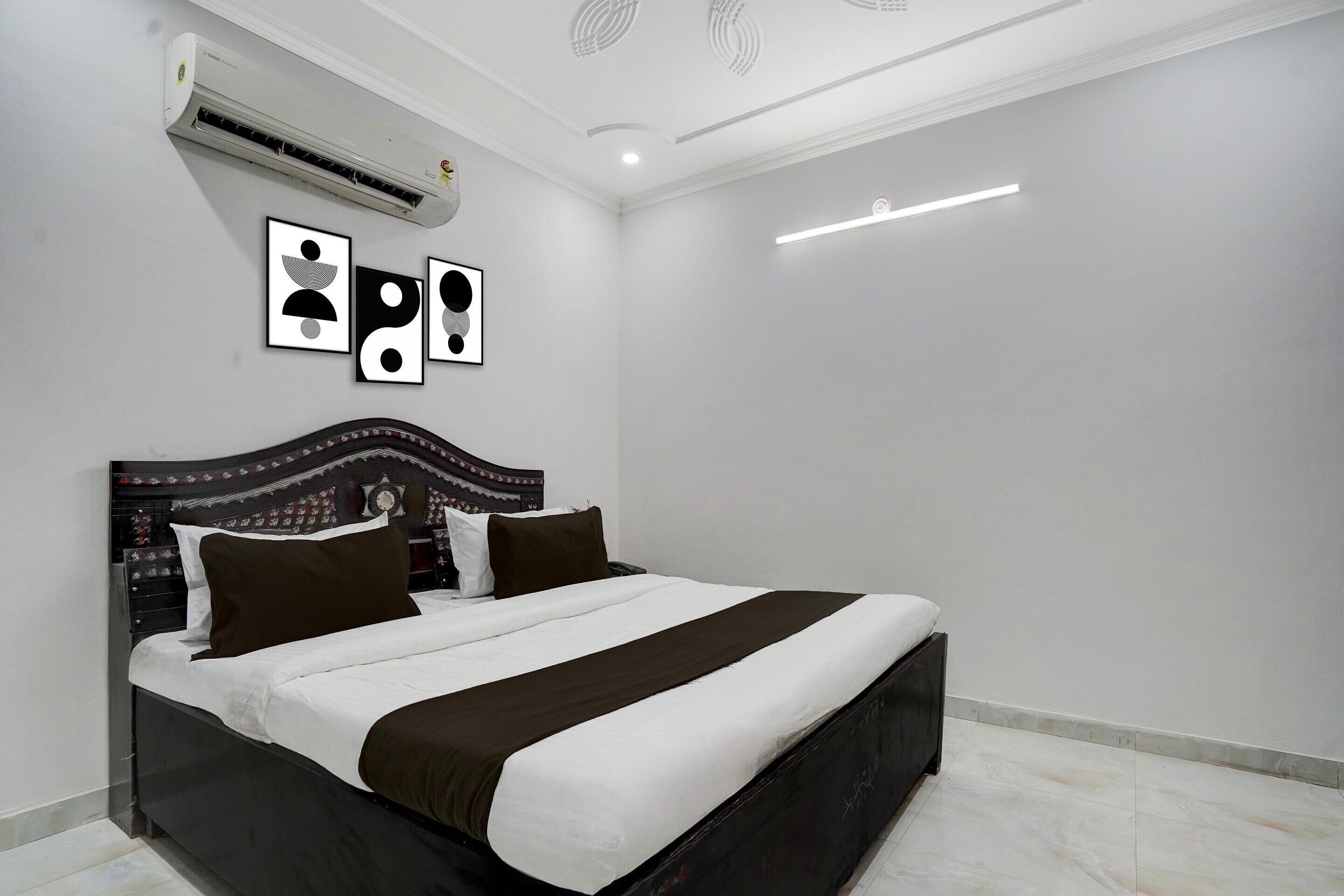 Une chambre moderne avec un grand lit, un appareil de climatisation et des œuvres d’art accrochées au mur.