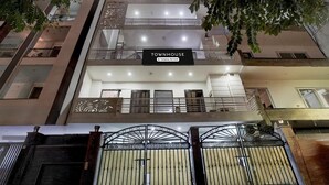 A multi-story building with a sign reading 'TOWNHOUSE' and a wheelchair accessibility symbol. - Classic With Balcony Huda Market Sector 46 (Gurugram)