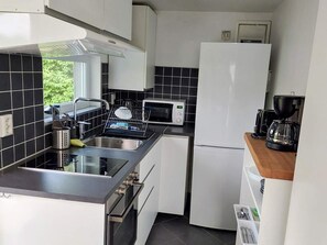 A compact kitchen with a microwave, coffee maker, and a dishwasher. - 4 Person Holiday Home in Falkenberg (Falkenberg)