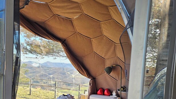 Ein Zimmer mit einem Bett, einem Fenster und Blick ins Freie.