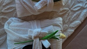 Ein weißes Handtuch mit schwarzem Stirnband und einer Blume auf einem Holzboden.