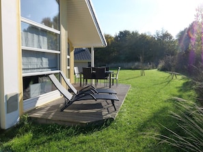 A deck with outdoor furniture, a covered patio, and a grassy yard. - 4 Star Holiday Home in Grossenbrode (Grossenbrode)