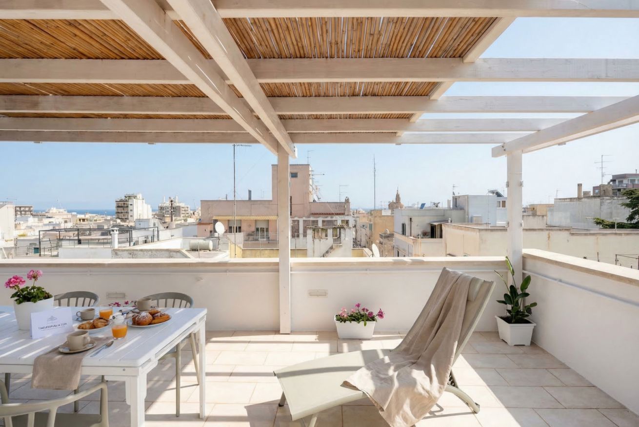 A rooftop terrace with a table set for breakfast, a chair, and potted plants.
