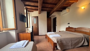 A bedroom with two beds, wooden headboards, a wooden desk, a television, and a door. - Hotel Terme Ristorante (Acquasanta Terme)