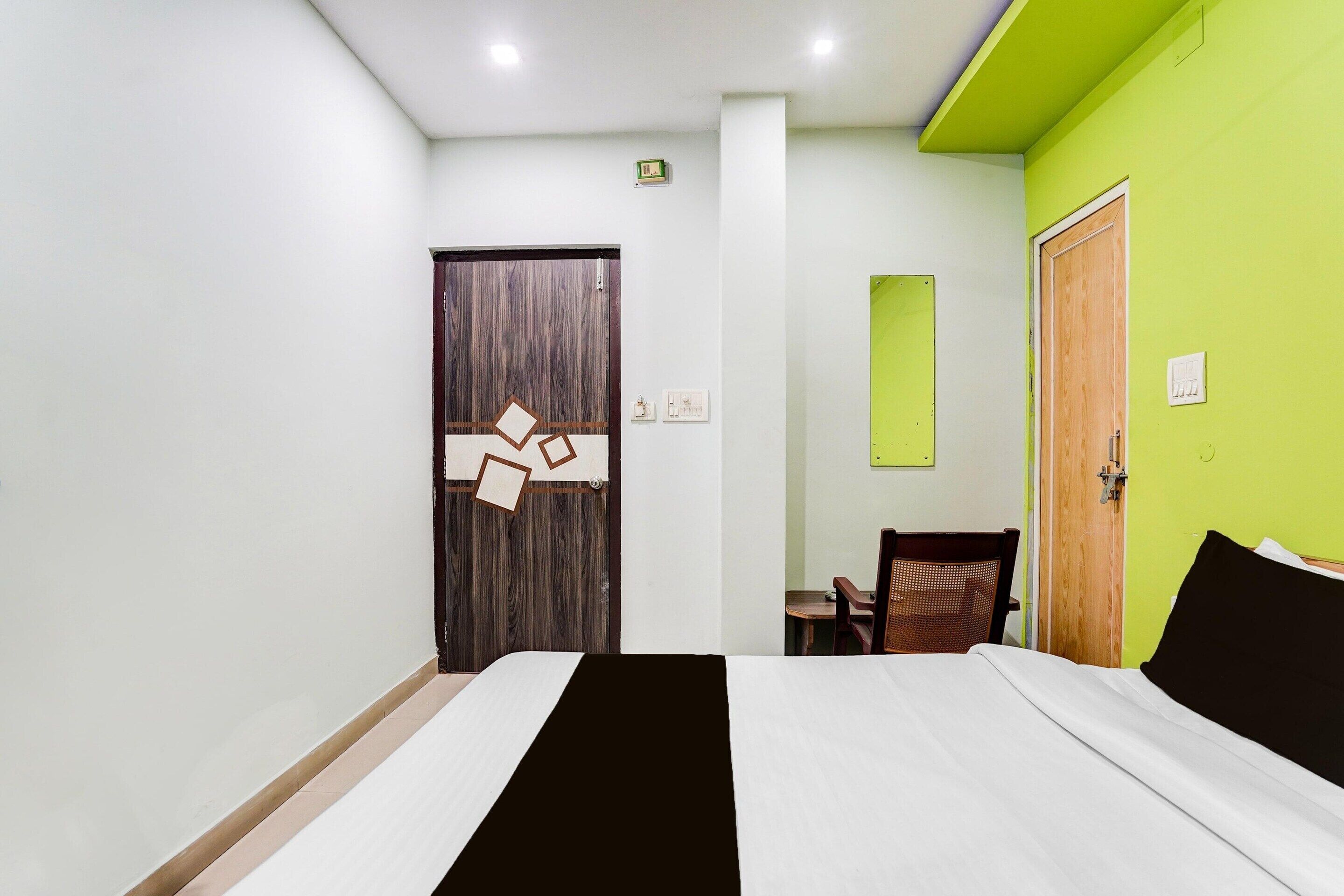 A hotel room with a bed, a desk, and a chair.