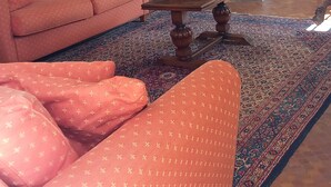 Ein Wohnzimmer mit einer Couch, einem Couchtisch, einem Kamin und einem Bild an der Wand.