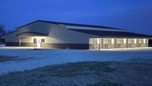 A large industrial building with a flat roof, multiple entry points, and a gravel-covered ground. - 4 Corners Event Center (Elk Falls)