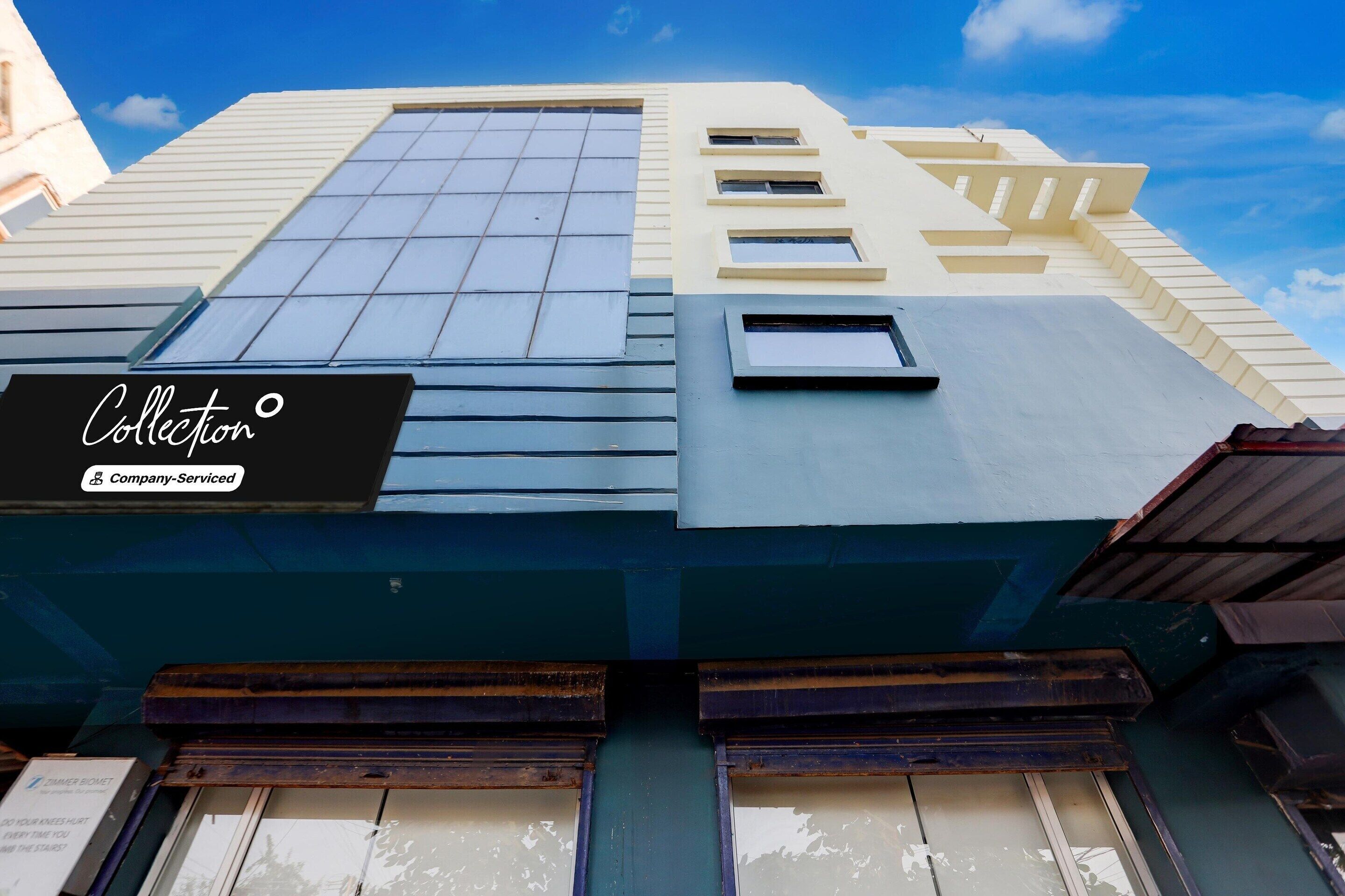 A building with a modern architectural style, featuring a prominent glass facade and a sign that reads 'Collection.'
