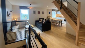 Ein modernes Interieur mit Treppe, Essbereich und Wohnzimmer mit Sofa und Tisch.