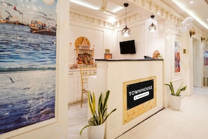 A reception desk with a sign reading 'TOWNHOUSE Company Serviced.' - Deluxeramesh Palace (Prayagraj)