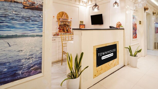 Een receptiebalie met een bord waarop 'TOWNHOUSE Company Serviced' staat.