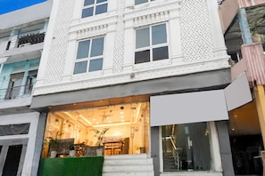 A multi-story building with a ground-floor restaurant or cafe, large windows, and a staircase leading to an upper floor. - Deluxeramesh Palace (Prayagraj)