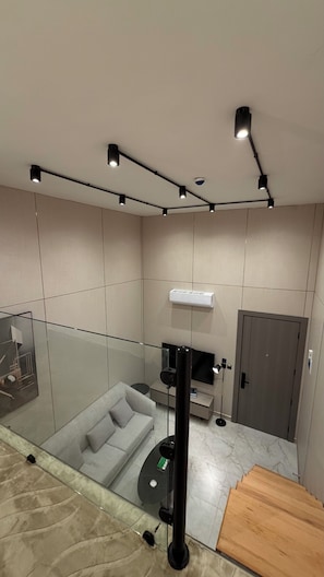Ein modernes Wohnzimmer mit einer Couch, einem Fernseher, einem Couchtisch und einer Holzbank.
