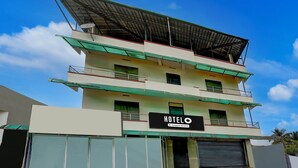 A multi-story hotel with a sign reading 'HOTEL O'. - Deluxe Kakkanad Diamond (Kanayannur)