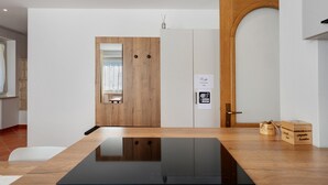 Een moderne kamer met een houten deur, een witte muur met een raam, een zwarte tafel en een houten kast.