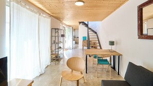 A modern interior with a wooden ceiling, a staircase, a dining area, and a living space. - 2-bedroom villa in beautiful Faro with cool AC breeze (Faro)