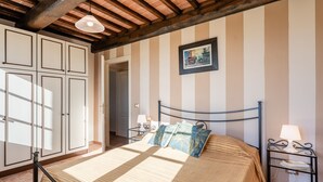 A bedroom with a bed, bedside tables, a wardrobe, and a picture on the wall. - Il Girasole Apartment with Swimming Pool (Capannori)