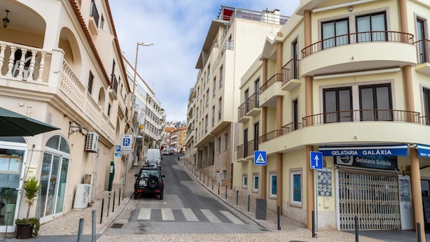 Une vue de rue avec des bâtiments, un passage piéton et une enseigne indiquant la présence d’une gelateria nommée Galàxia.