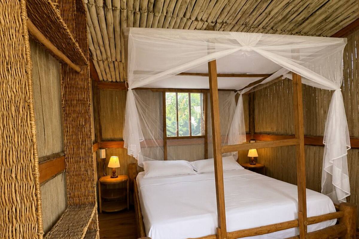 A rustic wooden room with a four-poster bed, woven walls, and a window.