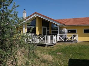 A yellow building with a red-tiled roof, a white porch, and a chimney. - 4 Star Holiday Home in Grossenbrode (Grossenbrode)