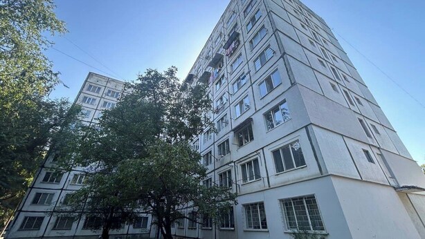 En bygning med flere etager, en flad facade, flere vinduer og altaner.