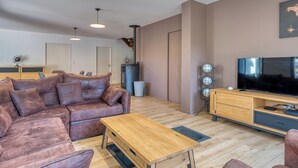 Un salon moderne avec un canapé en cuir, une table basse en bois et un téléviseur à écran plat.