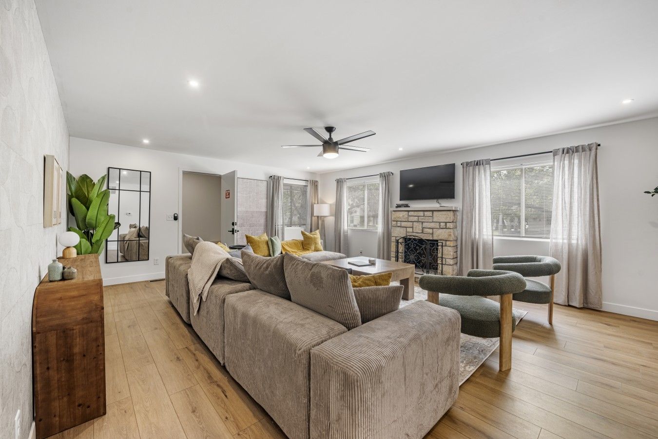 A modern living room with a sofa, a dining table, and a fireplace.