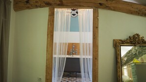 A room with a wooden ceiling, a patterned floor, a sink, and a mirror with an ornate frame.