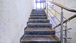 Een trap met metalen leuning en stenen treden die naar een hoger gelegen niveau leiden.