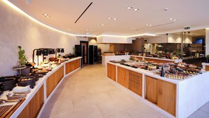 Un buffet moderne proposant une variété de plats, des meubles en bois et un intérieur propre et bien éclairé.