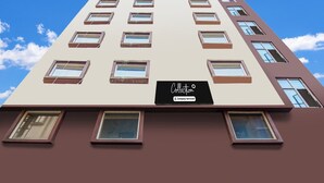 A multi-story building with a sign indicating it is a company-serviced collection. - Classic With Twin Bed Hotel Paradise (Barasat)