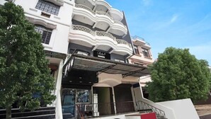 A multi-story building with balconies, a storefront, and a staircase leading to the entrance. - Deluxe Royal Stay Inn (Prayagraj)