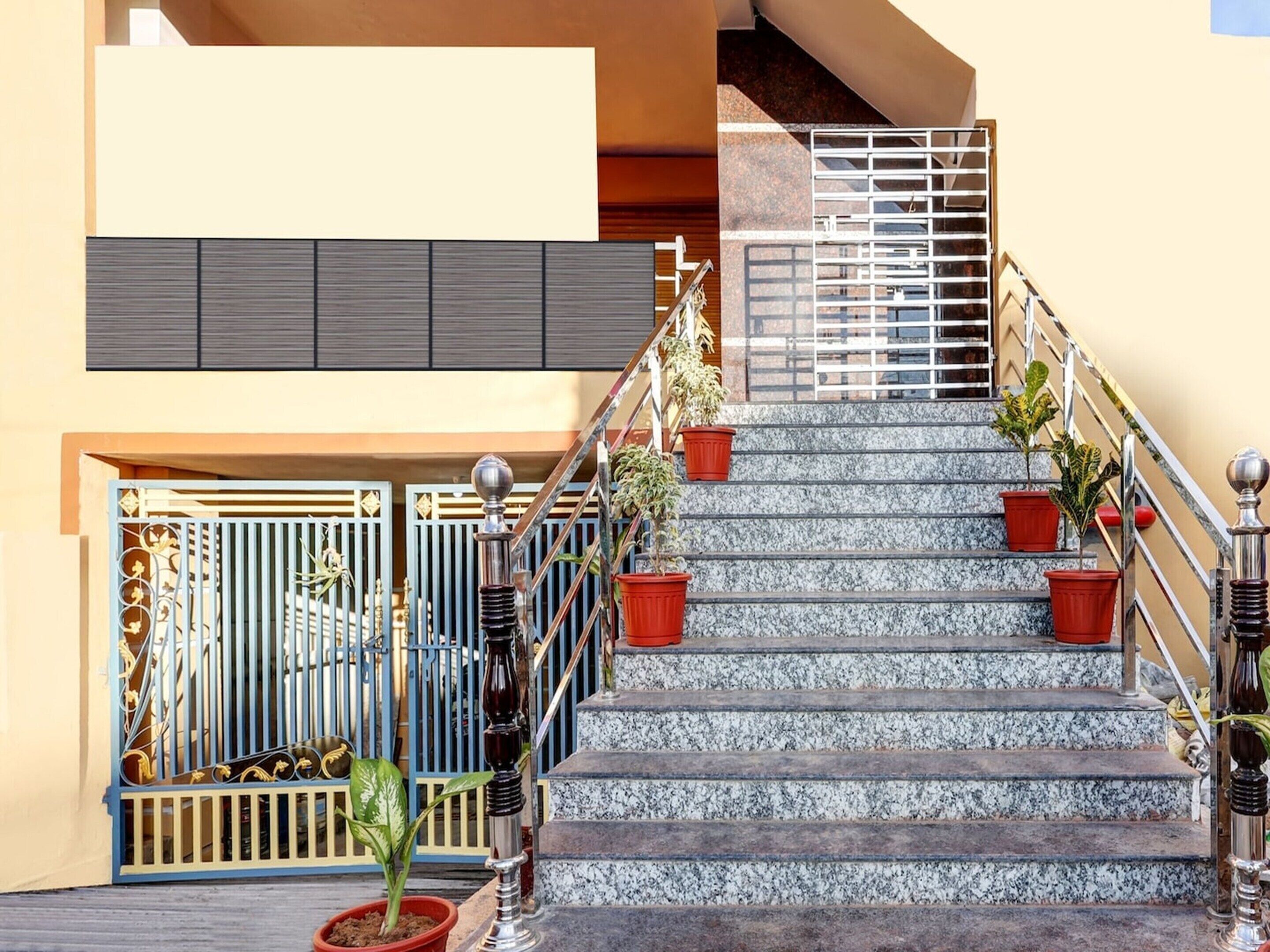 A staircase with potted plants, metal railings, and a gated entrance.