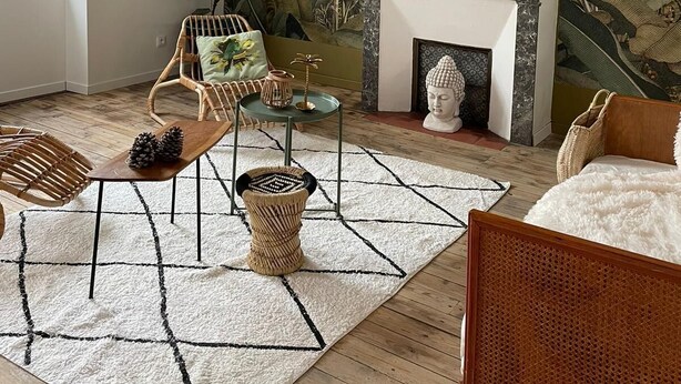 A living room with a tropical mural, wicker furniture, a fireplace, and a starfish decoration.
