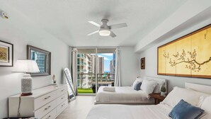 A modern hotel room with a large bed, a ceiling fan, a view of the city, and a traditional artwork on the wall. - Plush Brickell 1BR | Free Parking | Resort Pool (Brickell)