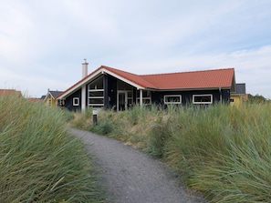 A modern house with a red-tiled roof, a chimney, and a pathway leading to the entrance. - 4 Star Holiday Home in Grossenbrode (Grossenbrode)
