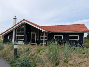 A modern house with a red-tiled roof, large windows, and a chimney. - 4 Star Holiday Home in Grossenbrode (Grossenbrode)