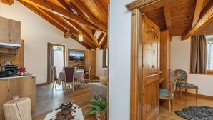 A wooden interior with a dining area, kitchen, and a large wooden door. - Apt "Homewood": rustic design with park and biolago (Pinzolo)