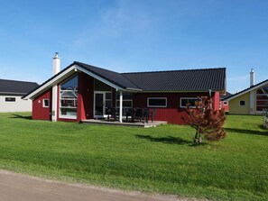 Een rood gebouw met een overdekte patio en schoorsteen.