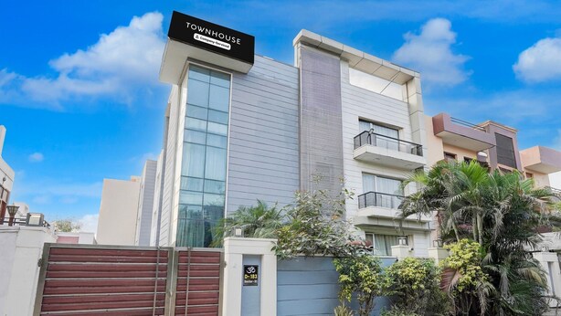 A modern townhouse with a gated entrance, a sign indicating a company service, and a section number. - Townhouse Sector 51 Noida (Noida)