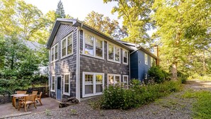 A two-story house with a patio and a gravel driveway. - Calma Azul ~ A Retreat in the Heart of C-Ville (Charlottesville)