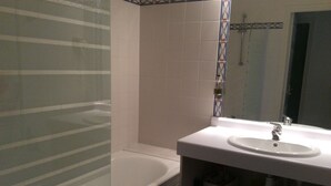 Ein Badezimmer mit Badewanne, Waschbecken und Spiegel.