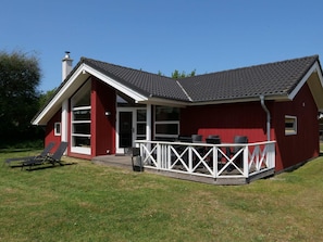 Ein rotes Gebäude mit einer weißen Veranda und einem großen Fenster.