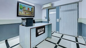 Ein Hotelrezeptionstresen mit einem gerahmten Gemälde, einer Klimaanlage und einem Check-in-Schalter.