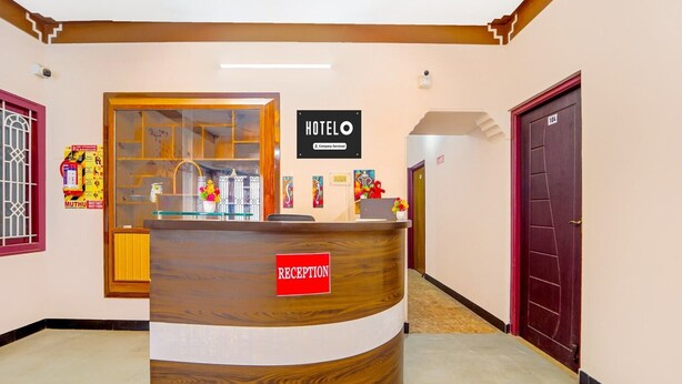 A hotel reception desk with a reception sign, a company service sign, and a reception area. - Deluxecrystal inn (Coimbatore)