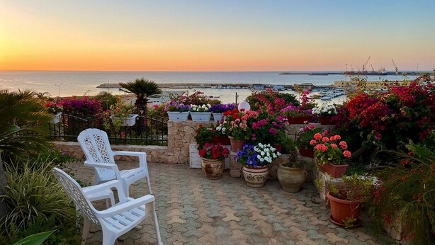 A patio with potted plants and a white chair, overlooking a marina with boats and cranes. - Casa Mare Holiday, Beachfront villa equipped with amenities and beach nearby (Sicilia)