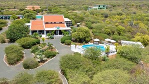 Un edificio moderno con piscina rodeada de jardines ajardinados.
