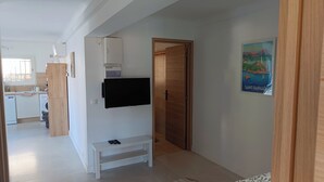 A modern kitchen with a built-in oven, microwave, and a flat-screen TV mounted on the wall. - Sea view apartment - XXL terrace - Beach 30 m away (Saint-Raphaël)
